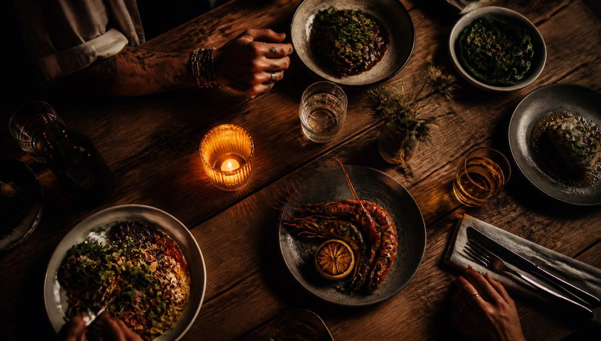 A candlelit dinner table full of shared plates